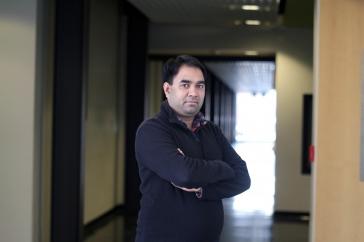 研究er Harish Vashisth stands with arms crossed in darkened hallway